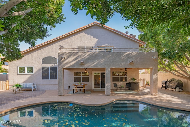 rear view of property with ceiling fan, a patio area, and fence