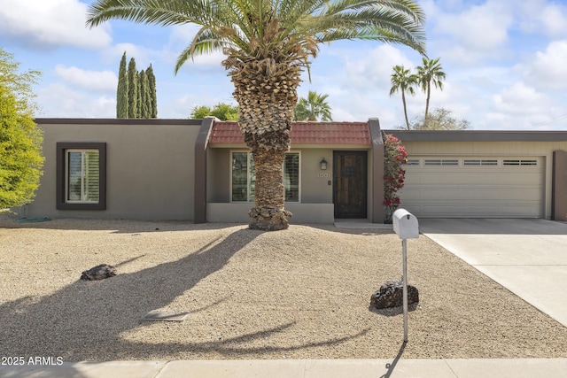 view of front of property with a garage, a tiled roof, driveway, and stucco siding