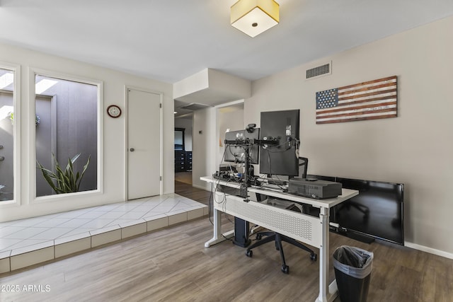 home office with baseboards, visible vents, and wood finished floors