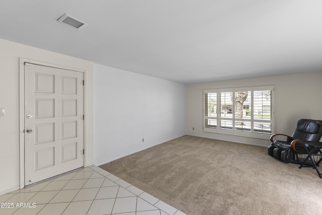 living area featuring light carpet, visible vents, and light tile patterned flooring