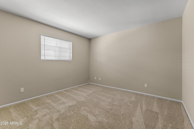 carpeted spare room with baseboards