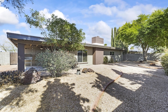 rear view of house with a patio area, fence, a chimney, and ceiling fan