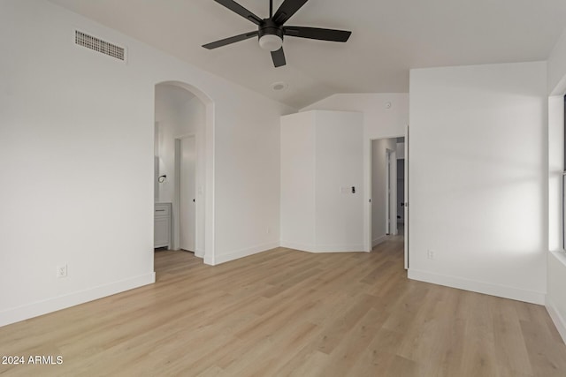 spare room with ceiling fan, light wood-type flooring, and vaulted ceiling