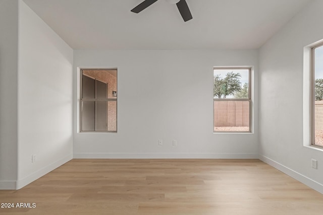 empty room with ceiling fan and light hardwood / wood-style flooring