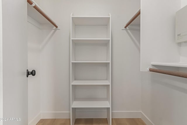 walk in closet with light hardwood / wood-style flooring