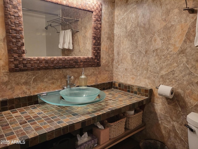8220 E Garfield St Unit M214, Scottsdale, AZ 85257 - bathroom featuring toilet, tile walls, a sink, and backsplash