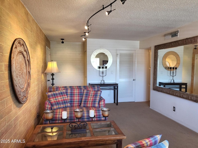 8220 E Garfield St Unit M214, Scottsdale, AZ 85257 - living room with a textured ceiling, visible vents, brick wall, and carpet flooring