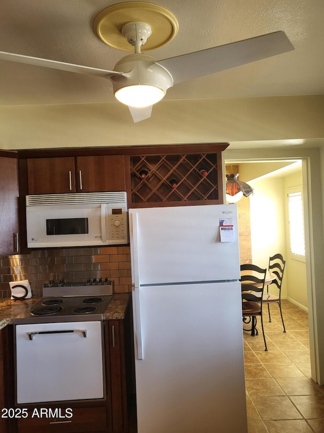 8220 E Garfield St Unit M214, Scottsdale, AZ 85257 - kitchen featuring light tile patterned floors, decorative backsplash, dark countertops, baseboards, and white appliances