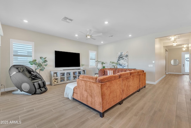 living area featuring light wood-style floors, recessed lighting, a wealth of natural light, and visible vents