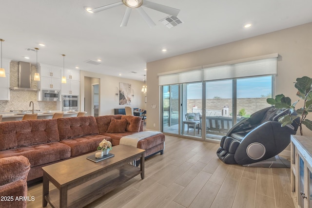 living area with a water view, light wood-style floors, visible vents, and recessed lighting