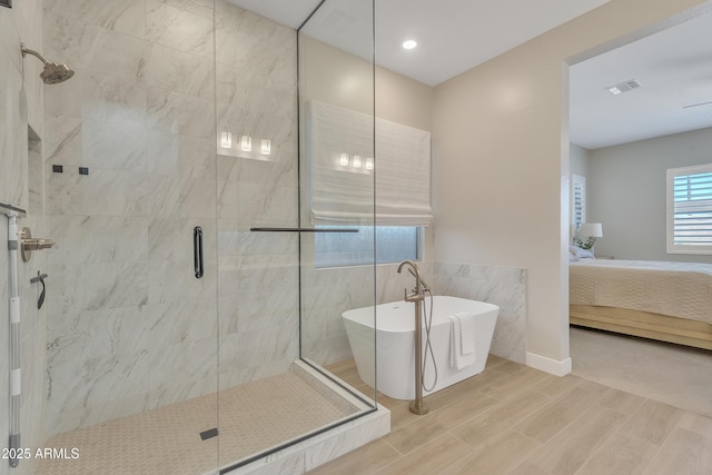 ensuite bathroom featuring visible vents, a freestanding bath, ensuite bathroom, a shower stall, and wood finished floors