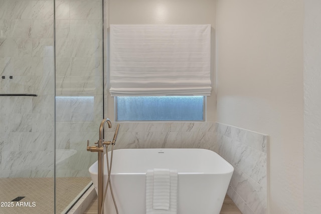 bathroom with tile walls, a freestanding bath, and tiled shower