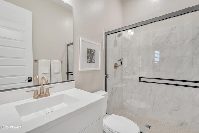 full bath featuring vanity, a shower stall, and toilet