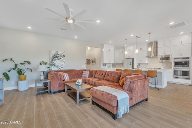 living room with wood tiled floor, visible vents, and recessed lighting