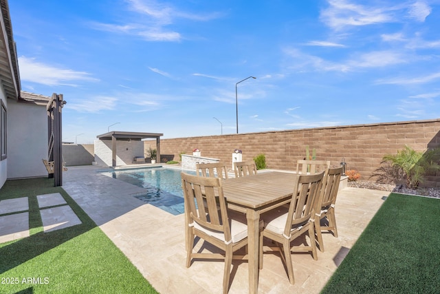 view of patio / terrace featuring a fenced backyard, outdoor dining area, a fenced in pool, and an outbuilding