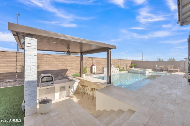 view of pool featuring a patio, a fenced backyard, exterior kitchen, outdoor wet bar, and a pool with connected hot tub