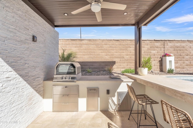 view of patio with a ceiling fan, outdoor wet bar, fence, and area for grilling