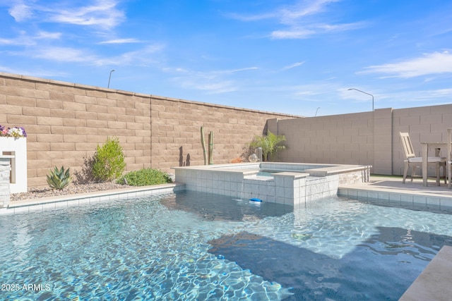 view of swimming pool with fence and a pool with connected hot tub