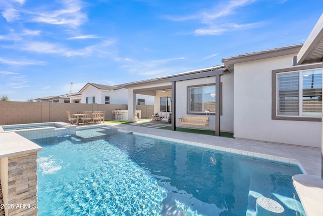 view of pool featuring a patio, fence, and a pool with connected hot tub