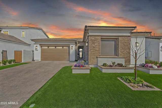 view of front of home featuring an attached garage, a lawn, and concrete driveway