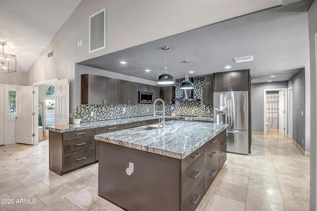 2405 E Lynwood Cir, Mesa, AZ 85213 - kitchen featuring stainless steel appliances, a sink, backsplash, dark brown cabinetry, and an island with sink