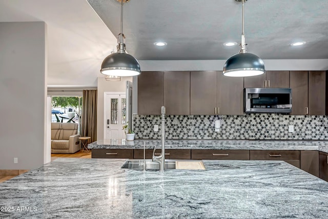 2405 E Lynwood Cir, Mesa, AZ 85213 - kitchen featuring stainless steel microwave, dark brown cabinets, light stone countertops, recessed lighting, and backsplash