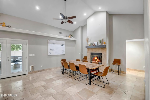 2405 E Lynwood Cir, Mesa, AZ 85213 - dining area with a tile fireplace, a ceiling fan, tile patterned floors, baseboards, and high vaulted ceiling