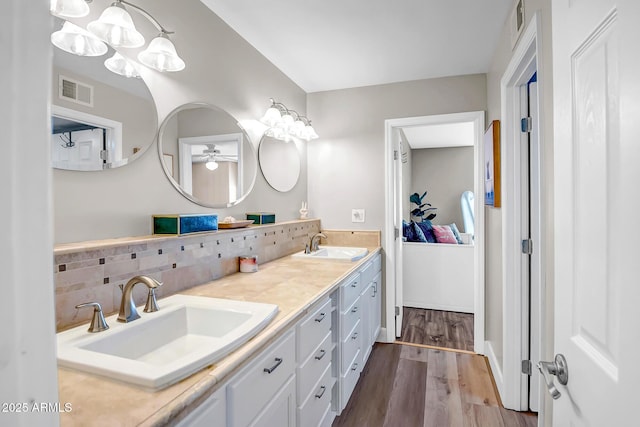 2405 E Lynwood Cir, Mesa, AZ 85213 - bathroom with double vanity, a ceiling fan, wood finished floors, decorative backsplash, and a chandelier