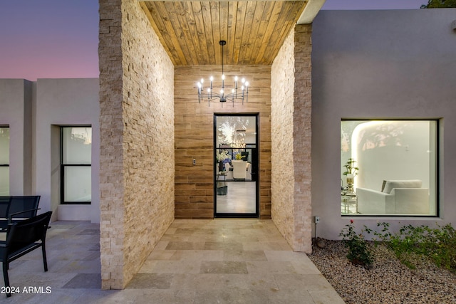 hallway with a chandelier and wooden ceiling