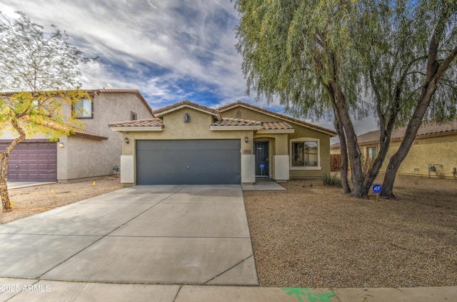 mediterranean / spanish-style home with stucco siding, a garage, driveway, and a tile roof