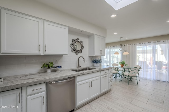 kitchen featuring stainless steel dishwasher, light stone counters, white cabinets, and sink