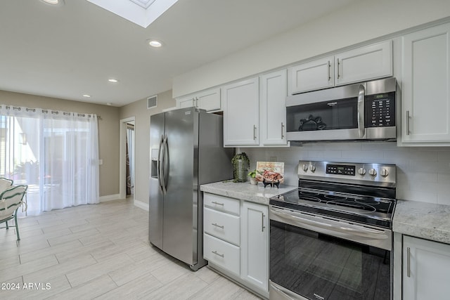 kitchen featuring white cabinets, decorative backsplash, and stainless steel appliances