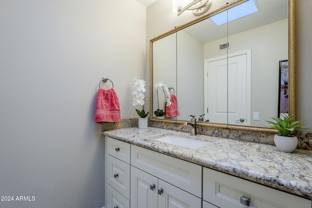 bathroom featuring vanity and a skylight