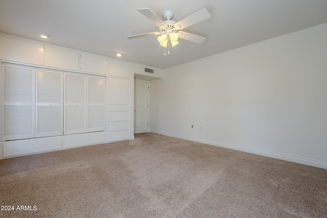 unfurnished bedroom featuring ceiling fan, a closet, and carpet floors