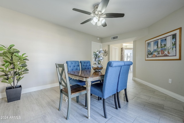 dining space with ceiling fan and light hardwood / wood-style flooring