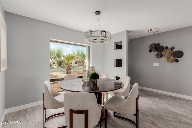 dining room with an inviting chandelier and light hardwood / wood-style flooring