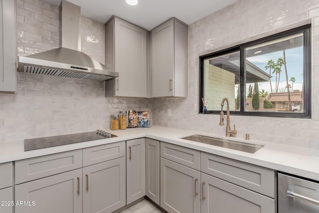 kitchen with sink, gray cabinets, dishwasher, black electric stovetop, and wall chimney exhaust hood