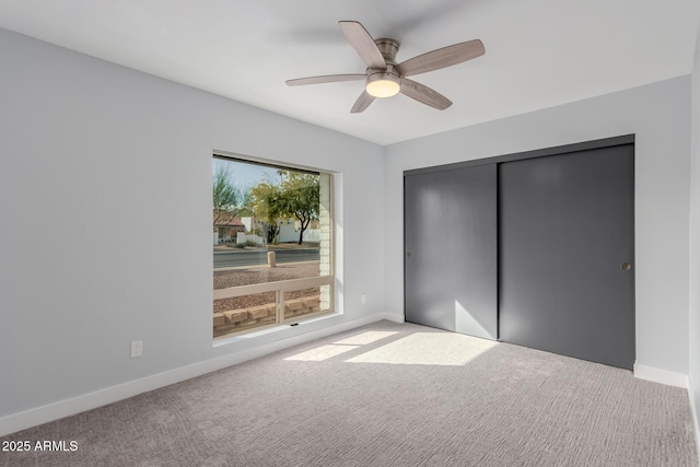 unfurnished bedroom with light colored carpet, a closet, and ceiling fan