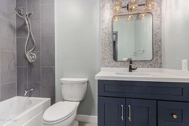 full bathroom with tiled shower / bath, vanity, and toilet