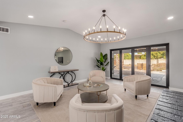 living room featuring vaulted ceiling, light hardwood / wood-style floors, and french doors