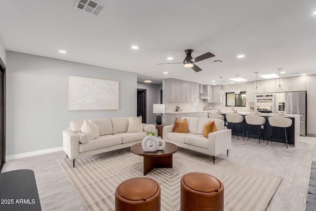 living room with ceiling fan and light hardwood / wood-style flooring