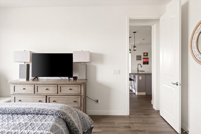 bedroom featuring sink and dark wood-type flooring