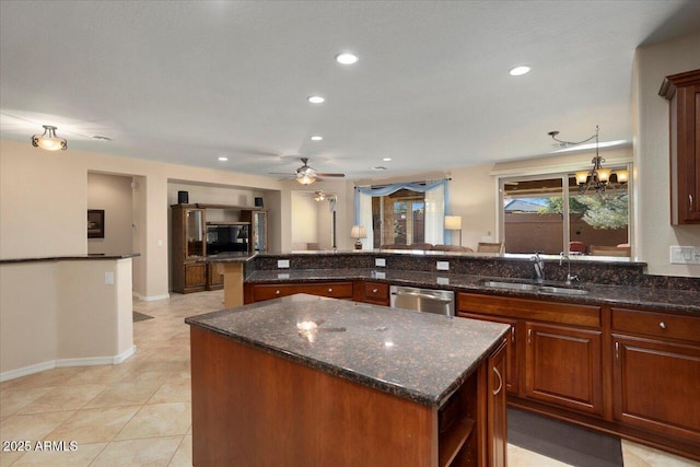 kitchen featuring dark stone countertops, sink, stainless steel dishwasher, and a kitchen island