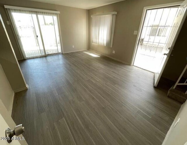 5420 W Lynwood St, Phoenix, AZ 85043 - unfurnished living room featuring baseboards and dark wood finished floors