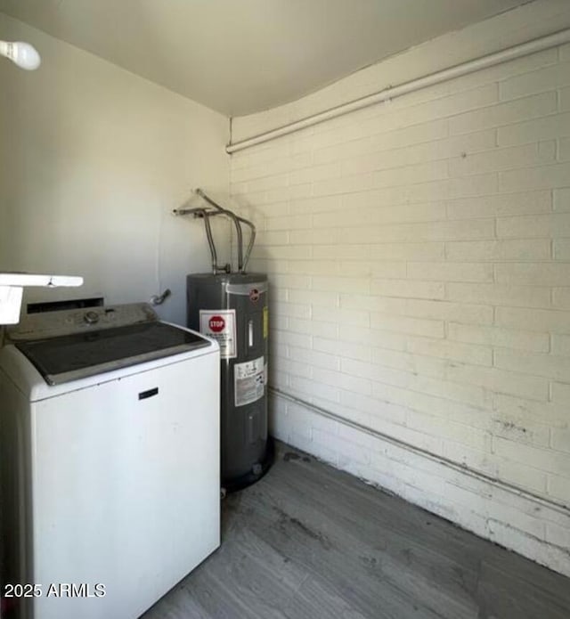 5420 W Lynwood St, Phoenix, AZ 85043 - laundry area featuring dark wood-type flooring, electric water heater, brick wall, washer / dryer, and laundry area