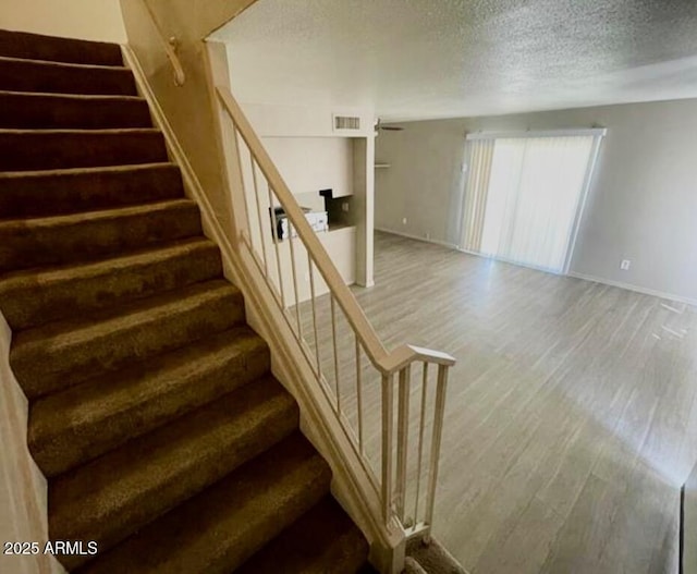 5420 W Lynwood St, Phoenix, AZ 85043 - stairway featuring baseboards, a textured ceiling, visible vents, and wood finished floors