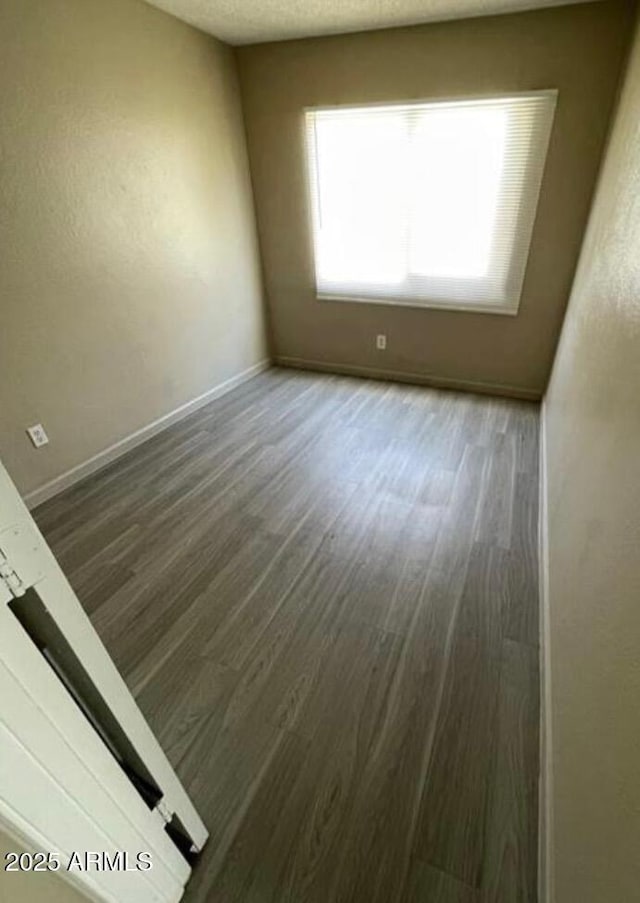 5420 W Lynwood St, Phoenix, AZ 85043 - empty room with a textured ceiling, baseboards, and wood finished floors