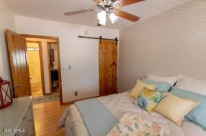 3458 N Meadow Dr, Pine, AZ 85544 - bedroom with a barn door, wood finished floors, and a ceiling fan
