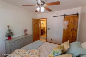 3458 N Meadow Dr, Pine, AZ 85544 - bedroom featuring a barn door and a ceiling fan