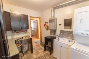 3458 N Meadow Dr, Pine, AZ 85544 - washroom with estacked washer and dryer, water heater, and cabinet space